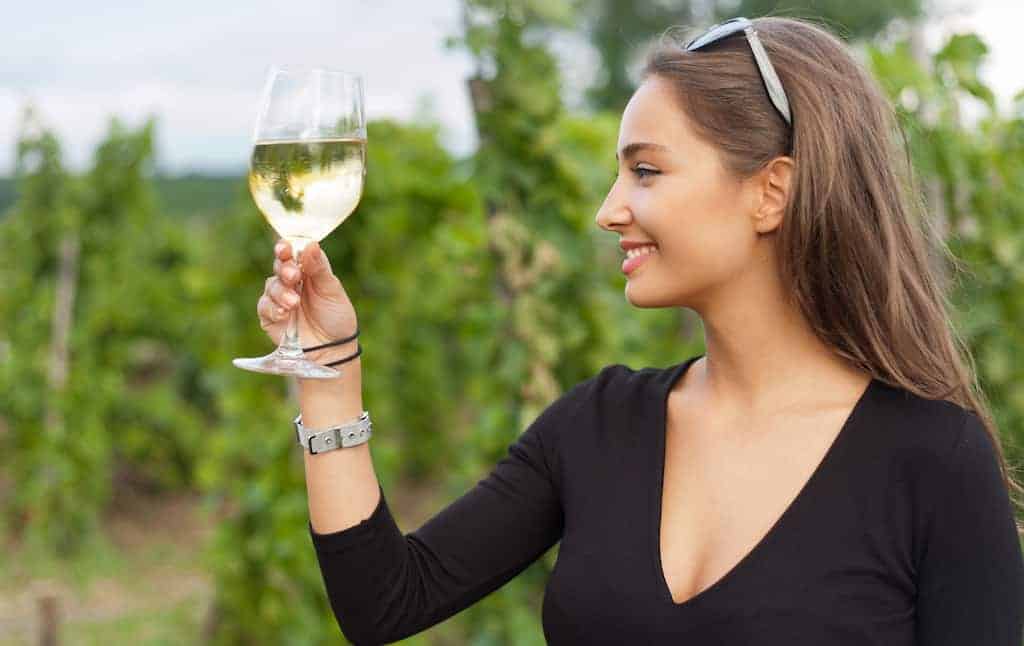 Woman looking at a wine glass wondering about sulfites