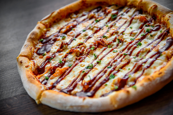 Pizza with chicken and barbeque sauce . Italian pizza on wooden table background