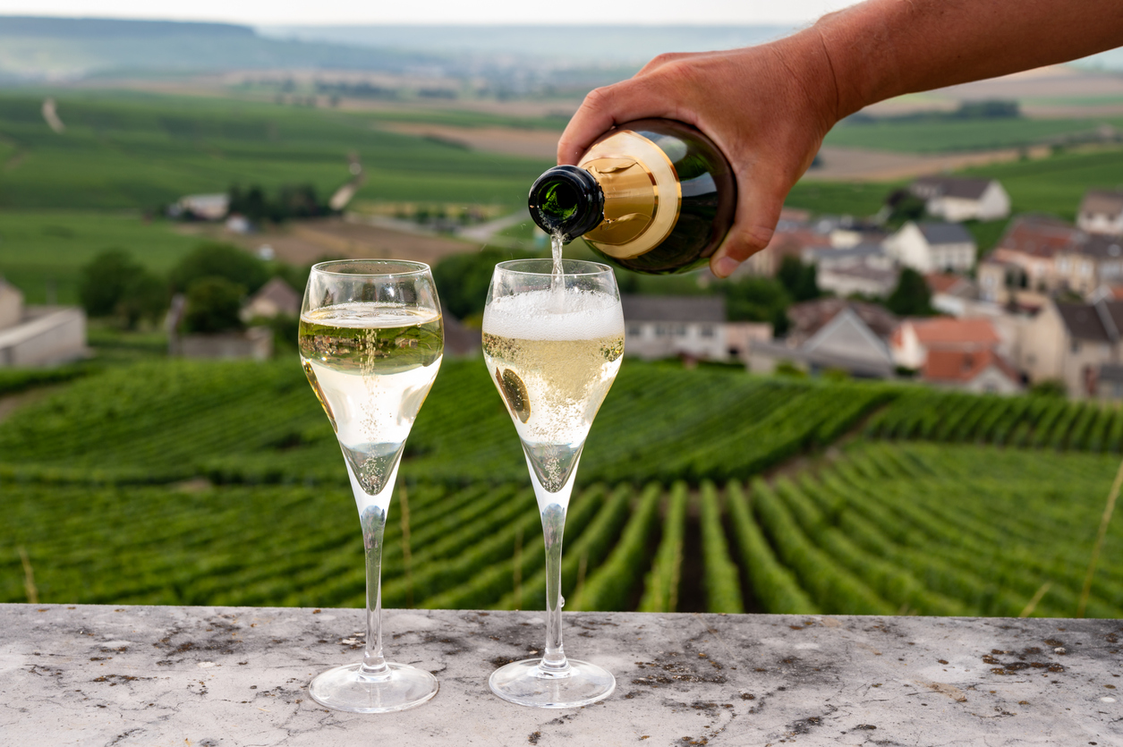 Pouring grower Champagne by a vineyard in the Champagne region