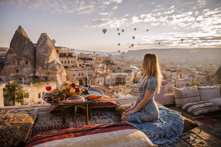 Sipping on local wines while taking in the mesmerizing beauty of Cappadocia's Goreme National Park and the stunning hot air balloons soaring above