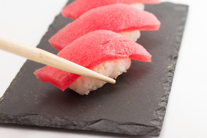 Nigiri with chop sticks on a stone platter