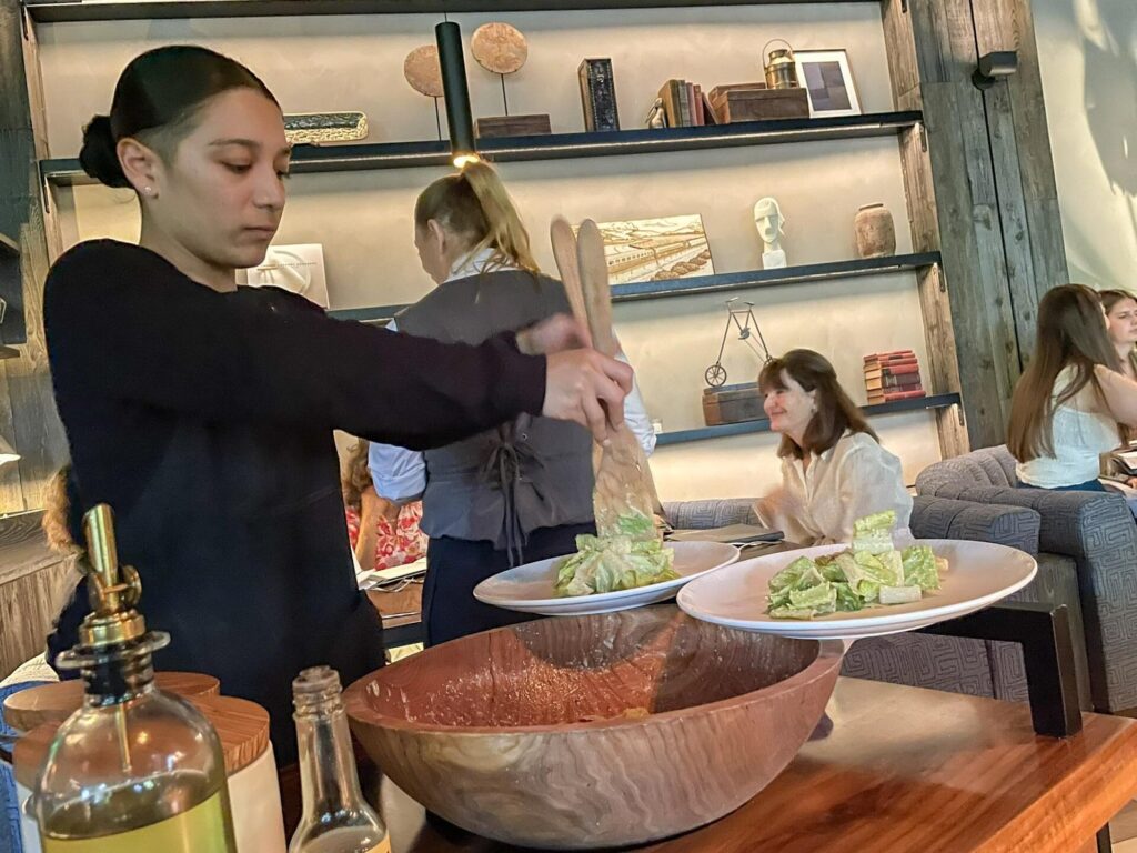 A Caesar salad being prepared tableside at BOA Steakhouse